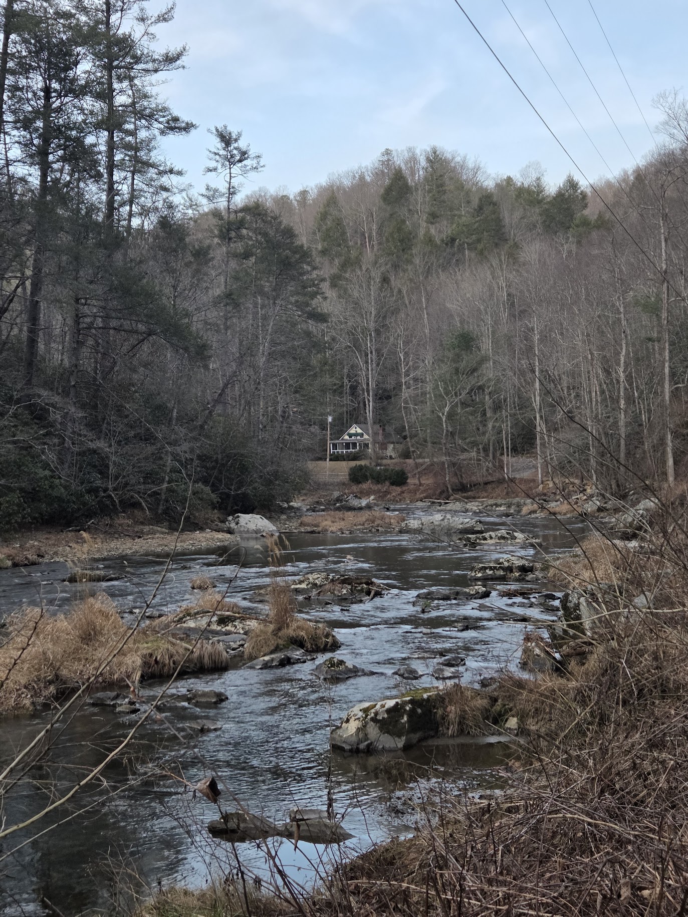 A view of the Riverbend Cottage cottage rental from a view on the Laurel River Trail in Western North Carolina.